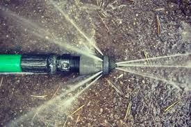Cleaner using hydro jet hose to remove dirt and debris from a commercial area